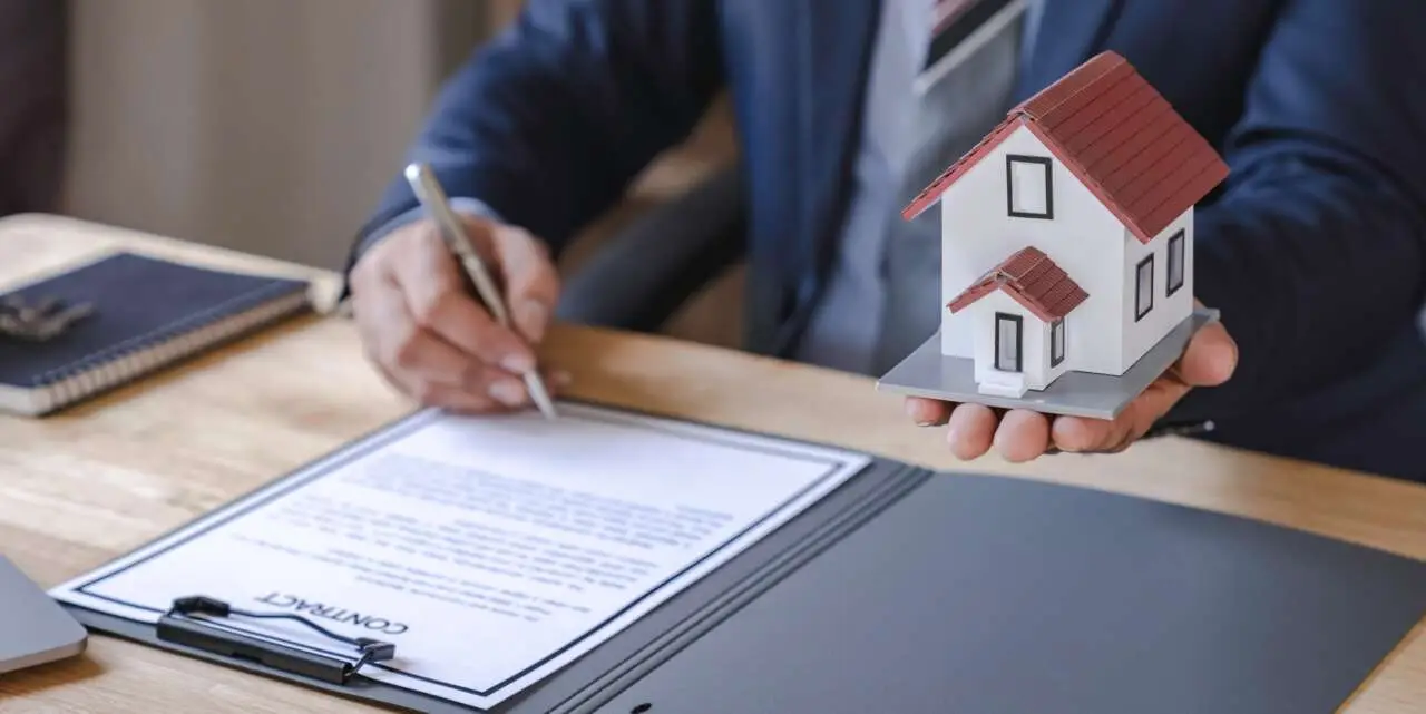 Businessman signing signature loan document to homeownership. Mortgage and real estate property inve
