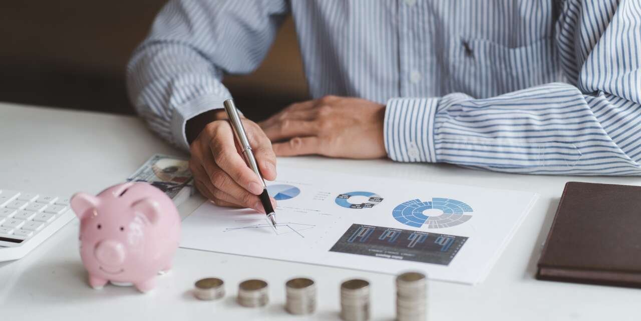 Business people planning financial statements with piggy bank and stack coin, investment and financi