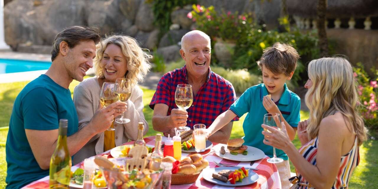 Caucasian three generation family enjoying lunch at table in the garden