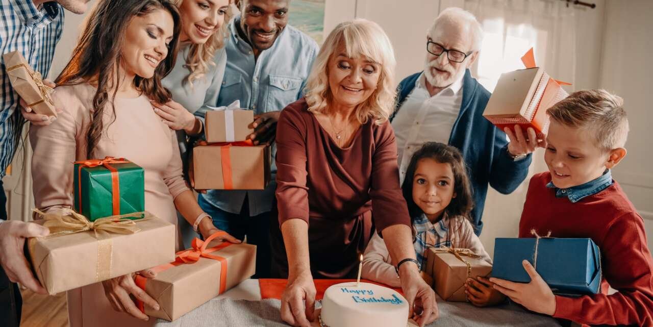 large family with birthday cake and gift boxes