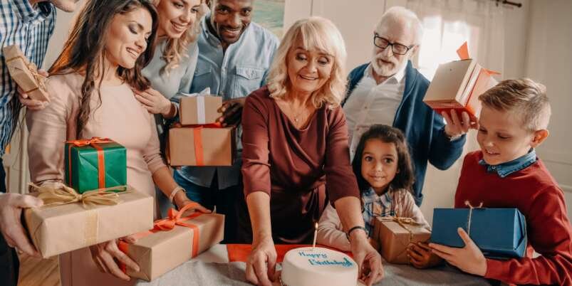 large family with birthday cake and gift boxes