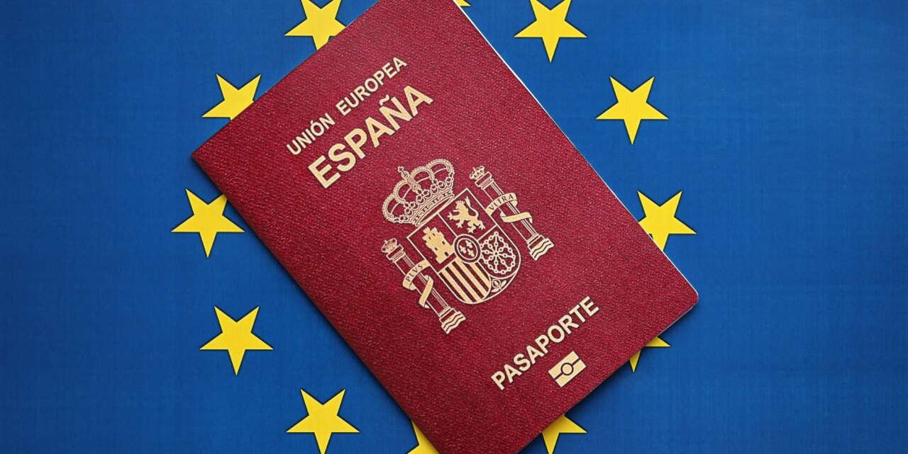 Red Spanish passport of European Union on blue flag background close up