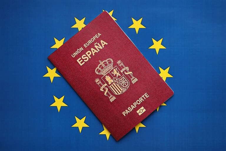 Red Spanish passport of European Union on blue flag background close up