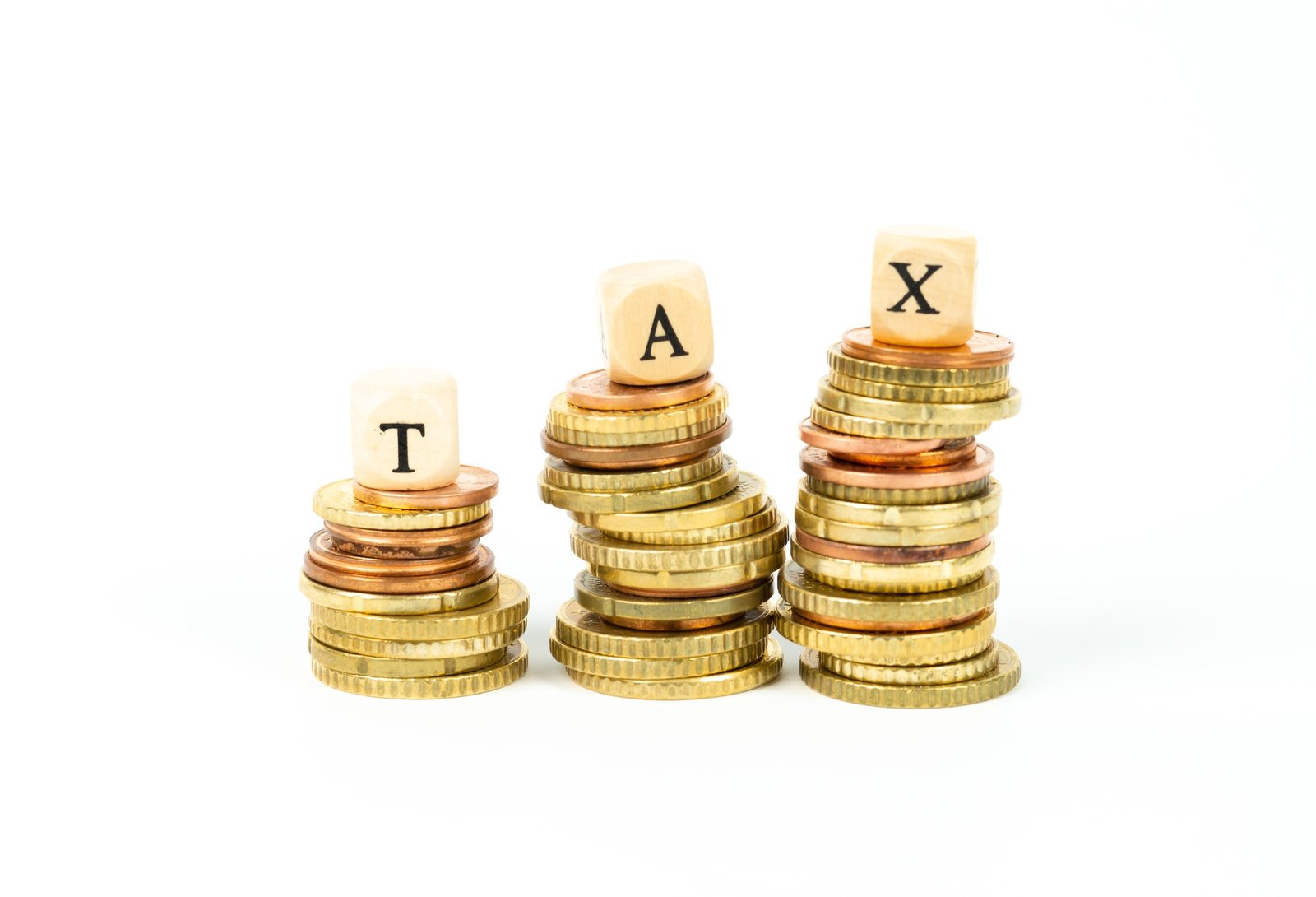 Stacks of coins and the word TAX made of cubes