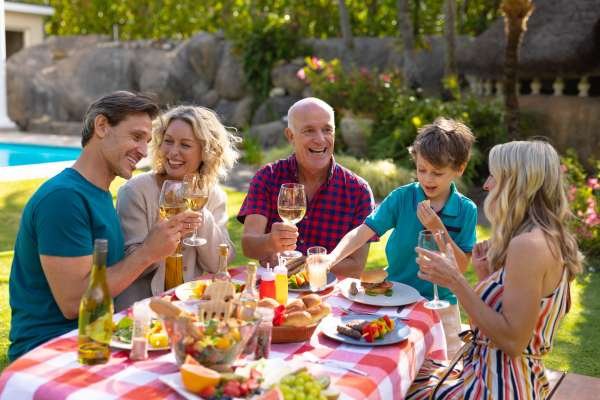Caucasian three generation family enjoying lunch at table in the garden